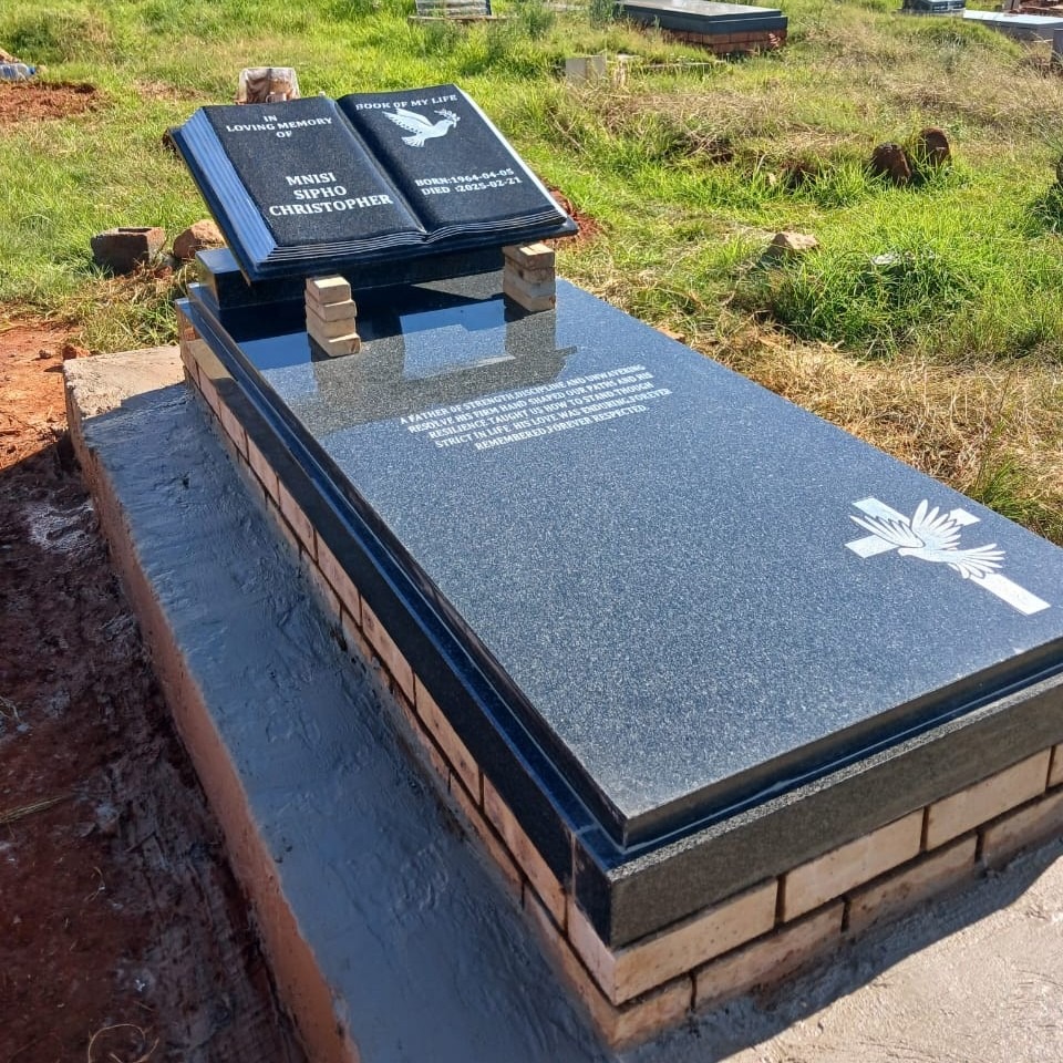 Angled view of polished black granite tombstone with engraved epitaph and cross motif by Mkhonto Tombstones Witbank