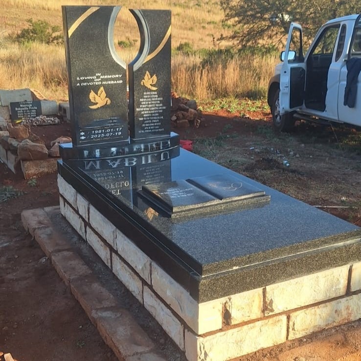 Double-pillar black granite tombstone with gold dove engravings, installed by Mkhonto Tombstones